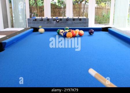 Boules de billard avec des numéros sur eux sur une table de billard bleue en action de frapper Banque D'Images