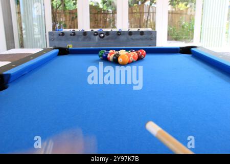 Boules de billard avec des numéros sur eux sur une table de billard bleue en action de frapper Banque D'Images