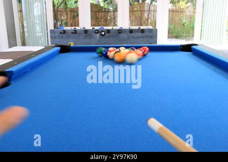 Boules de billard avec des numéros sur eux sur une table de billard bleue en action de frapper Banque D'Images