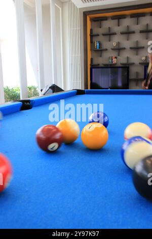 Boules de billard avec des numéros sur eux sur une table de billard bleue en action de frapper Banque D'Images