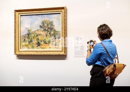 AMSTERDAM - 09/10/2024, Une femme regarde l'œuvre paysage près d'Aix avec Tour de Cesar de Paul Cézanne issue de la nouvelle exposition vive l'impressionnisme ! Au musée Van Gogh. L’exposition présente les plus belles œuvres impressionnistes françaises issues de collections néerlandaises. ANP ROBIN VAN LONKHUIJSEN pays-bas OUT - belgique OUT Banque D'Images