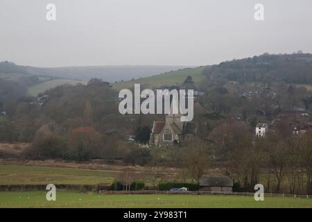 Église historique à Alfriston, Sussex de l'est, nichée dans une vallée hivernale pittoresque avec des collines ondoyantes et des vues sur la campagne rustique. Banque D'Images