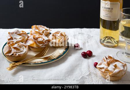 Tartes délicatement confectionnées, saupoudrées de sucre en poudre, servies sur de la porcelaine fine avec des couverts dorés, parfaites pour une célébration de Noël luxueuse Banque D'Images