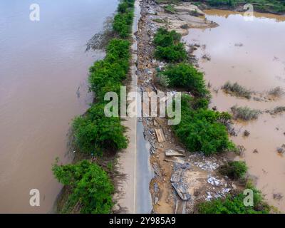Les glissements de terrain causés par les fortes pluies ont causé la fissuration des routes asphaltées. Les catastrophes naturelles causées par les inondations ont endommagé et coupé la surface de la route Banque D'Images