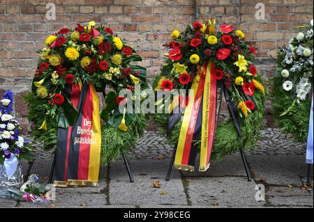 09 octobre 2024, Saxe-Anhalt, Halle (Saale) : des couronnes de fleurs, dont une avec un ruban du président fédéral, sont déposées devant la synagogue de Halle. La ville de Halle commémore les victimes de l'attaque terroriste de 2019, lorsqu'un attaquant armé a tenté d'entrer dans la synagogue. Quand il a échoué, il a tiré sur deux personnes et les a tuées dans la rue et dans un magasin de kebab. Photo : Heiko Rebsch/dpa Banque D'Images