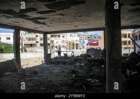 Les Palestiniens quittent la zone avec certains de leurs effets personnels après une attaque de l'armée israélienne contre l'école Salah al-DIN dans la ville de Gaza. Banque D'Images