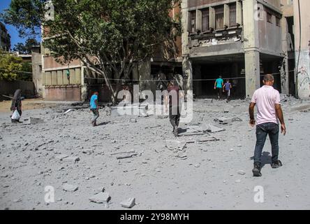 Des Palestiniens ont été vus autour de la zone du bâtiment endommagé après une attaque de l'armée israélienne contre l'école Salah al-DIN dans la ville de Gaza. Banque D'Images