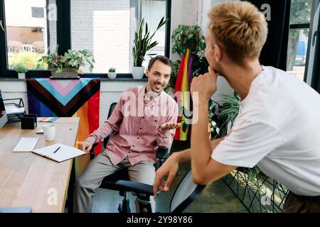 Deux hommes s'engagent dans une discussion chaleureuse et ludique tout en étant entourés de plantes et d'un décor vibrant. Banque D'Images