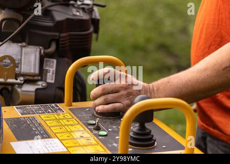 Le travailleur de la construction utilise de la machinerie lourde à l'aide d'un panneau de commande avec des leviers et des boutons. Mise au point sélective Banque D'Images