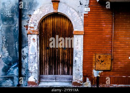 Porte en bois avec arche en marbre et mur de briques rouges Comacchio à Ferrare en Emilie Romagne Italie Banque D'Images