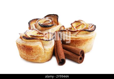 Roses de pomme fraîchement cuites et bâtonnets de cannelle isolés sur blanc. Pâte feuilletée Banque D'Images