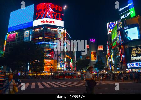 Shibuya Crossing : l'un des carrefours piétonniers les plus fréquentés au monde, réputé pour ses néons éblouissants et le chaos organisé de milliers de personnes Banque D'Images