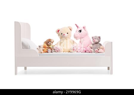 Jouets en peluche d'animaux en peluche doux sur un lit d'enfants isolé sur fond blanc Banque D'Images