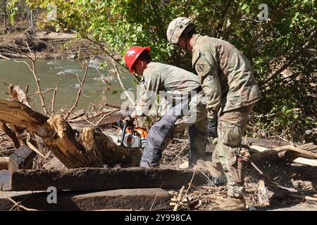 Toecane, États-Unis. 10 août 2024. Les soldats de l'armée américaine, affectés au 27th Engineer Battalion, utilisent une tronçonneuse pour enlever les débris à la suite des inondations causées par l'ouragan Helene, le 8 octobre 2024 à Toecane, Caroline du Nord. Crédit : SSGT. Arthur Ruepong/US Army/Alamy Live News Banque D'Images