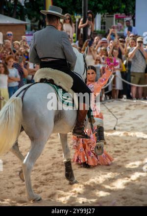 Fuengirola, Malaga, Espagne. Cavalier et danseur en robe de flamenco rose et chapeau, effectuant une recréation d'une danse sevillanas pendant la foire Banque D'Images