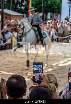 20/09/2024. Fuengirola, Malaga, Espagne. Spectateur enregistrant avec le téléphone portable la performance des cavaliers lors de la célébration de la journée du cheval Banque D'Images