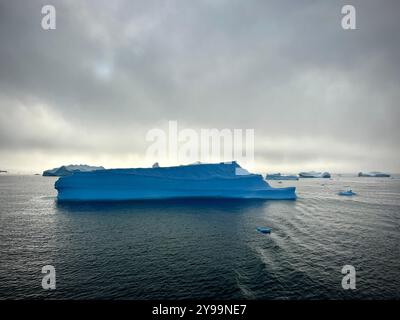 Icebergs spectaculaires sous le ciel Moody dans les eaux reculées de l'Antarctique Banque D'Images