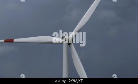 Éolienne ou éolienne en rotation pour générer de l'énergie électrique sur fond de ciel de nuages orageux Banque D'Images