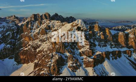 Vue aérienne des montagnes rocheuses étonnantes dans la neige au lever du soleil, Dolomites, Italie, Europe Banque D'Images