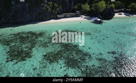 Vue aérienne de l'île tropicale des Philippines. Plage de sable blanc, falaises rocheuses montagnes avec baie bleue et magnifique récif corallien Banque D'Images