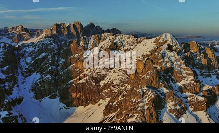 Vue aérienne des montagnes rocheuses étonnantes dans la neige au lever du soleil, Dolomites, Italie, Europe Banque D'Images