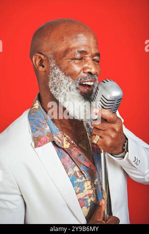 Chanteur, senior et homme noir au micro avec soul, jazz et musique old School avec style rétro en studio. Musicien, cool et chantant avec la chanson blues Banque D'Images