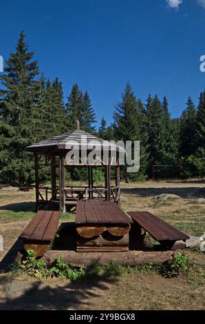 Un coin confortable avec une alcôve, une table en bois et des bancs pour se reposer dans une prairie forestière au pied du pic Noir sur la montagne Vitosha, Bulgarie Banque D'Images