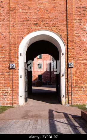 Landskrona, Suède - 12 février 2023 : bâtiment en briques vintage avec une grande entrée voûtée blanche, des portes en métal noir et une ambiance historique. Banque D'Images