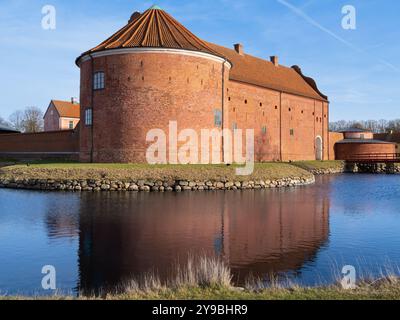 Landskrona, Suède - 12 février 2023 : Château historique à Citadella dans le sud de la Suède par l'eau, toit de tuiles rouges, tours rondes, cadre serein. Banque D'Images