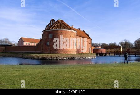 Landskrona, Suède - 12 février 2023 : Château historique par un canal d'eau tranquille avec une vieille tour de briques, personne au bord de l'eau, atmosphère sereine. Banque D'Images