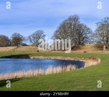 Landskrona, Suède - 12 février 2023 : canal tranquille au château Citadellas dans le sud de la Suède avec rivage rocheux, arbres sans feuilles et puits-dix Banque D'Images