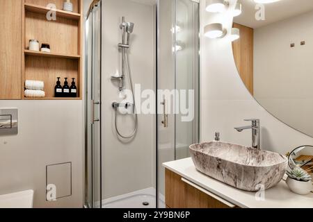 Cet élégant intérieur de salle de bains moderne dispose d'une douche et d'un évier magnifiquement conçus Banque D'Images