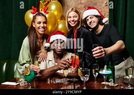 Un groupe de jeunes collègues divers porte un toast avec des boissons colorées lors d'une célébration festive. Banque D'Images