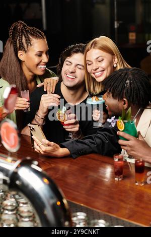 Quatre collègues partagent des moments joyeux et prennent un verre lors d'une fête d'entreprise animée après le travail. Banque D'Images