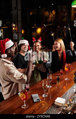 Les jeunes collègues élèvent joyeusement leur boisson, célébrant ensemble avec esprit festif et rire. Banque D'Images