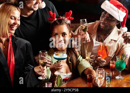 Les jeunes professionnels apprécient les cocktails et les rires lors d'un rassemblement de vacances dynamique entre amis. Banque D'Images