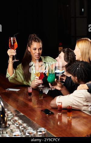 Les jeunes professionnels portent un toast avec des boissons colorées lors d'une réunion d'entreprise animée. Banque D'Images