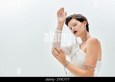 Une femme magnifique affiche sa tenue d'hiver confortable avec des gestes gracieux dans une atmosphère élégante. Banque D'Images