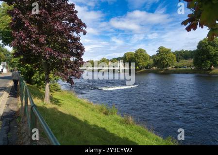 Regardant de l'autre côté de la rivière Ness et descendant vers le centre d'Inverness. Montrant les gens traversant un pont à maillons de chaîne blancs à River Ness Island Walk, le célèbre Banque D'Images