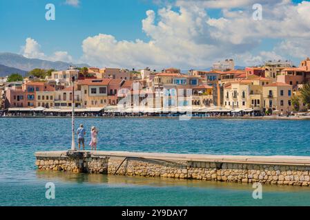 Vacances de couple retraité, vue d'un couple d'âge moyen regardant le front de mer du port vénitien de la vieille ville à Chania (Hania), Crète, Grèce Banque D'Images