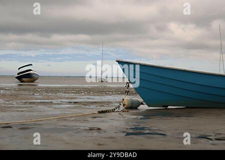 Bateau à rames bleu échoue et repose sur le sable pendant la marée basse Banque D'Images