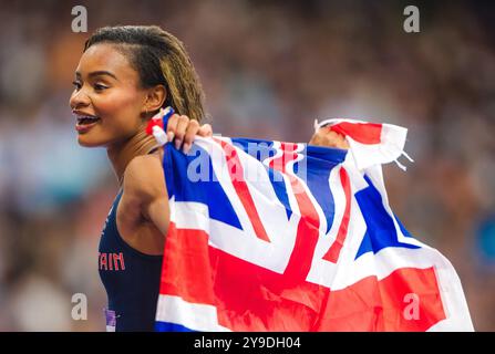 Imani-Lara Lansiquot célébrant avec le drapeau de son pays dans le relais 4x100 mètres aux Jeux Olympiques de Paris 2024. Banque D'Images