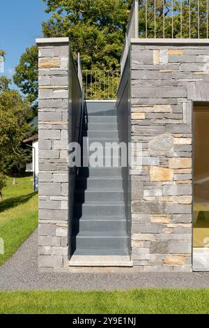 Détail de maison nouvellement fini d'un escalier extérieur menant à la terrasse. Les murs sont recouverts de pierre, vue frontale. Personne à l'intérieur Banque D'Images