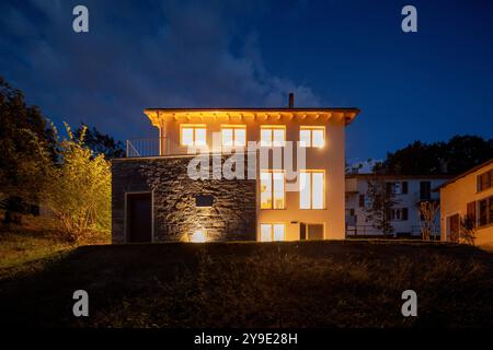 Maison individuelle juste rénovée, avec des finitions modernes. Arrière de la maison avec grand jardin verdoyant privé. Scène de nuit, personne à l'intérieur Banque D'Images