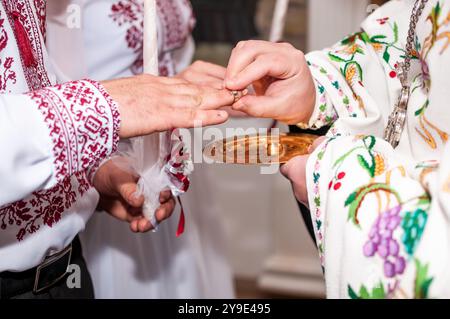 Cérémonie de l'amour : un échange traditionnel d'anneaux de mariage dans une tenue vibrante. Banque D'Images
