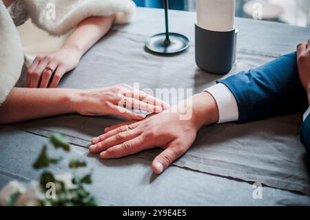 Connexion intime : un moment tendre entre deux mains lors d'une célébration. Banque D'Images