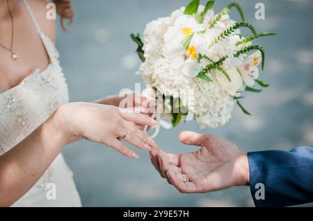 Moment de mariage romantique avec bouquet de mariée et mains entrelacées. Banque D'Images