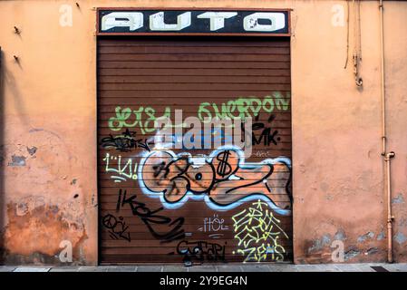 Ancien signe d'un garage avec le volet fermé et avec graffiti à Ferrare Italie Banque D'Images