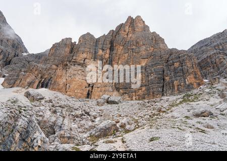 Pic de montagne rocheuse verticale de Sella Group par un jour nuageux. Grimpeur allant à la via ferrata Cesare Piazzetta au Piz Boè (col de Pordoi), Dolomites Banque D'Images