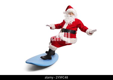 Père noël chevauchant une planche de surf isolé sur fond blanc Banque D'Images